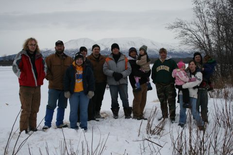 2003 Jeep TJ - A group of people stand in a snowy landscape with mountains in the background.