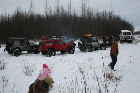 2003 Jeep TJ - Off-road vehicles gathered in a snowy area, with trees lining the horizon.