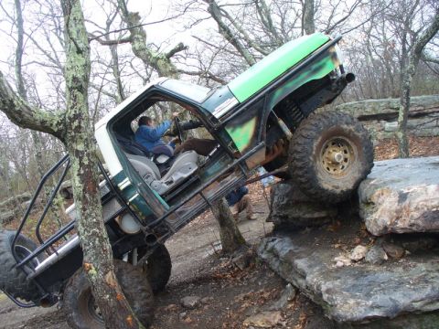 1978 Ford Bronco - 1978 Ford Bronco navigating a challenging rock obstacle on an off-road trail.