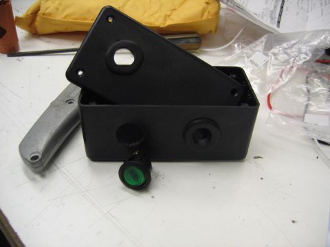 2001 Ford F-150 - A black plastic electrical enclosure with a green toggle switch is shown on a white surface.