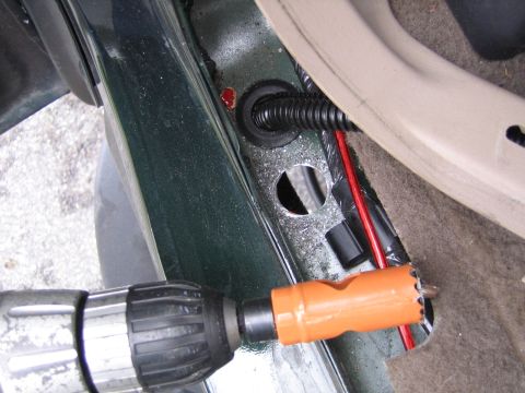 2001 Ford F-150 - Drilling a hole in the vehicle's body for wiring installation.