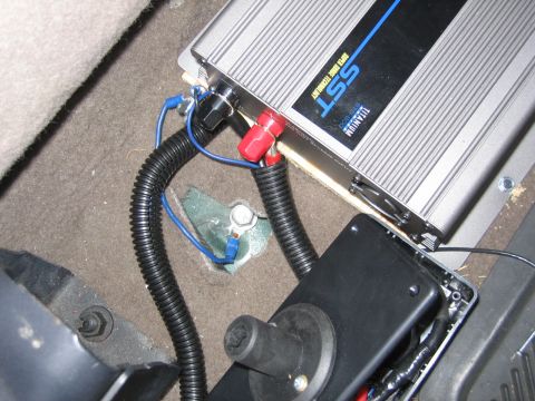 2001 Ford F-150 - Close-up of aftermarket car amplifier wiring and connections installed on the vehicle floor.