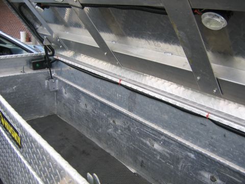 2001 Ford F-150 - Interior view of an open aluminum truck bed toolbox, showing wiring and a light fixture.