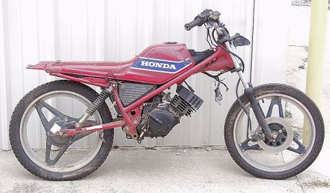1985 Ford Crown Victoria LTD - Side view of a red Honda motorcycle, showing engine and frame details.