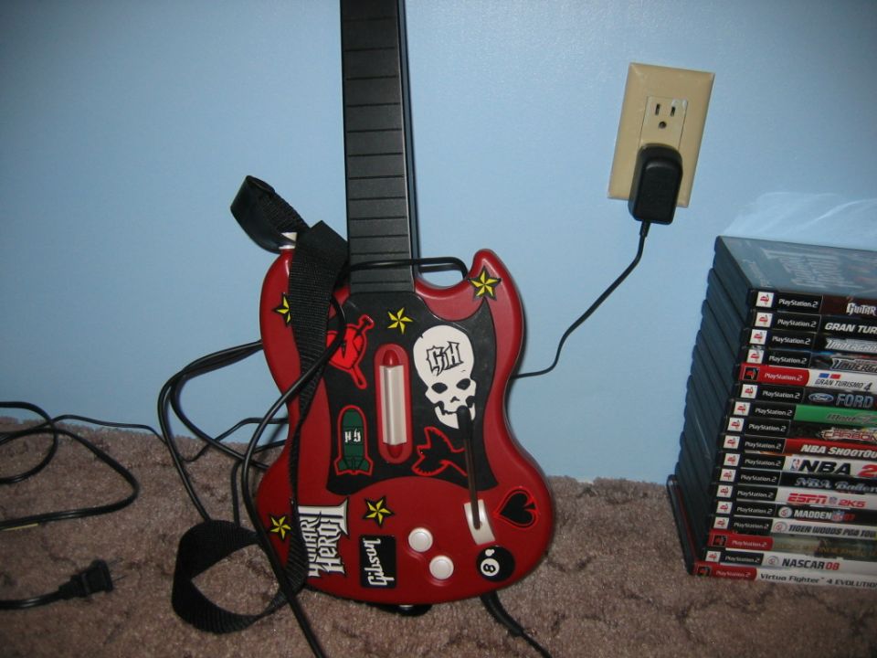 Red Guitar Hero controller with skull decal and 'Gibson' logo