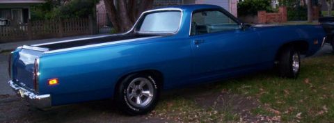 1970 Ford Ranchero - A blue 1970 Ford Ranchero is seen from the side, parked on a grassy area.