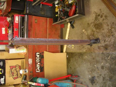1979 Ford Bronco - A rusty metal suspension component is shown in a workshop setting.