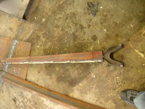 1979 Ford Bronco - A single metal suspension component, possibly from a vehicle's front suspension, is shown on a workshop floor.