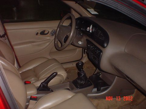2000 Ford Contour - The interior of a car is shown, tan leather seats and the dashboard with a watermark indicating the photo was taken in 2002.