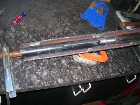 1979 Ford Bronco - A close-up view shows a metal suspension component clamped to a workbench, with tools and gloves present.