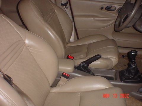 2000 Ford Contour - Interior view of a tan leather car cabin, showing the front seats and dashboard details.