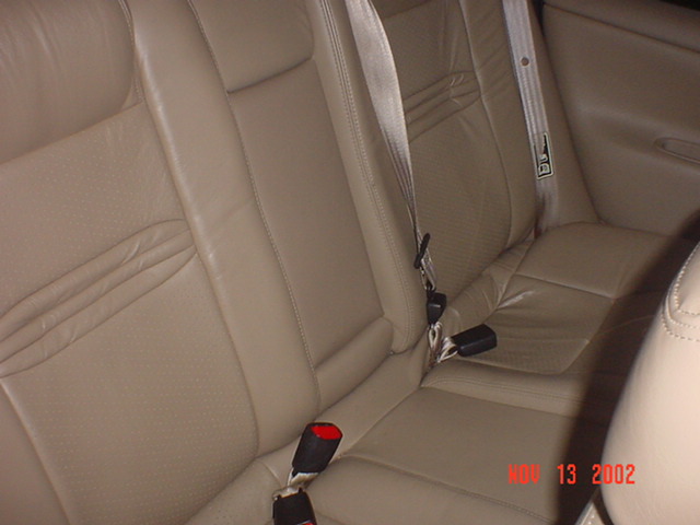 Tan leather rear seats with seatbelts. Watermark shows June 13, 2002