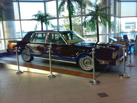 1999 Mercury Grand Marquis - A maroon 1999 Mercury Grand Marquis is displayed indoors with stanchions and velvet ropes.
