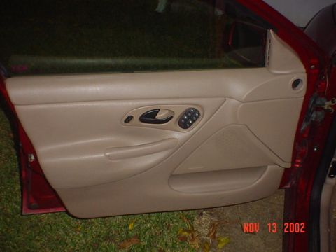 2000 Ford Contour - The interior door panel of a car is visible, controls for windows and locks, along with a watermark indicating a date in 2002.