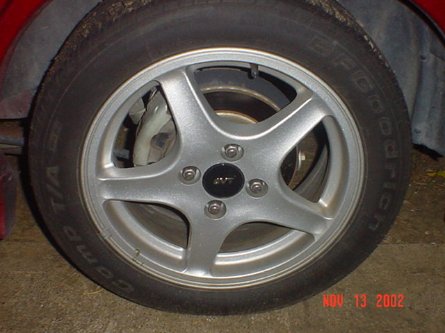 Silver SVT five-spoke alloy wheel with BFGoodrich Comp T/A tire on a red car