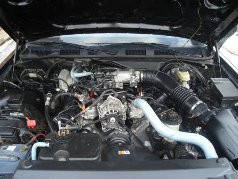 2000 Ford Crown Victoria - The engine bay of a vehicle, a V8 engine, air intake system, and battery. The registry claims it is a 2000 Ford Crown Victoria, but this ca…