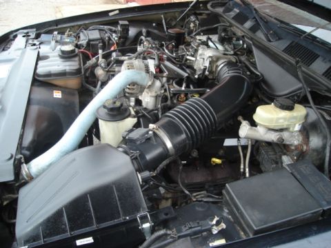 2000 Ford Crown Victoria - Engine bay of a 2000 Ford Crown Victoria, showing key components like the air intake and reservoirs.