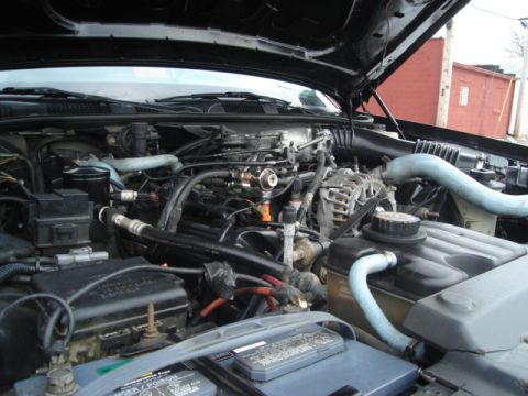 2000 Ford Crown Victoria - Close-up view of a car's engine compartment, showing the intricate network of parts and fluids.