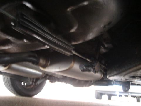 2000 Ford Crown Victoria - Undercarriage view of a vehicle, focusing on the dual exhaust system and a tire.