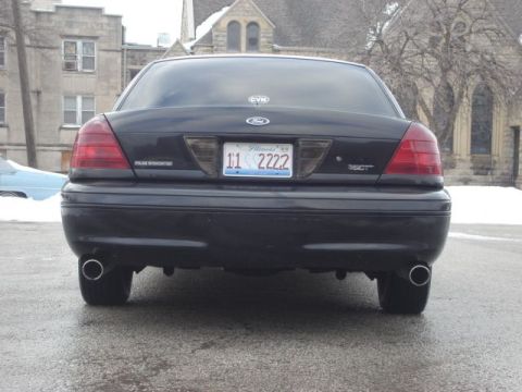 2000 Ford Crown Victoria - The rear of a black sedan is shown, its taillights and license plate.