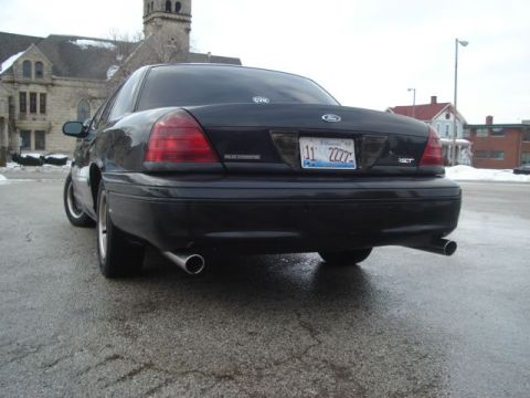 2000 Ford Crown Victoria - The rear of a black 2000 Ford Crown Victoria is visible with its dual exhaust pipes and license plate.