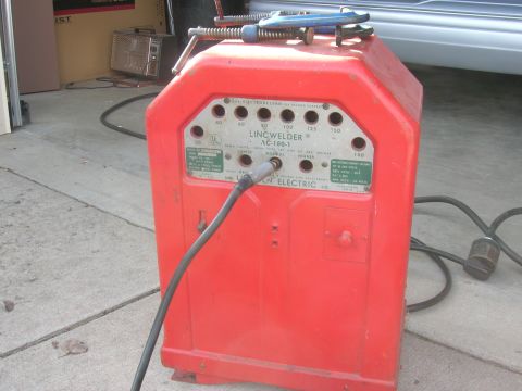 1979 Ford Bronco - A red Lincoln AC-180-T welder is shown with its control panel and attached cables.