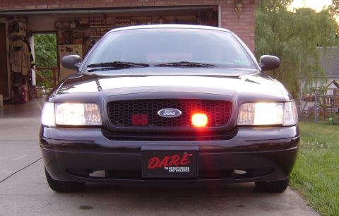 2003 Ford Crown Victoria - Black 2003 Ford Crown Victoria police car with DARE logo and light bar on the grille.