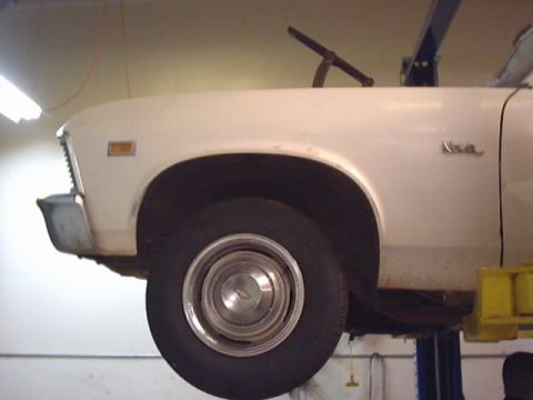 1969 Chevrolet Nova - The side profile of a white 1969 Chevrolet Nova is visible as it's elevated on a car lift.
