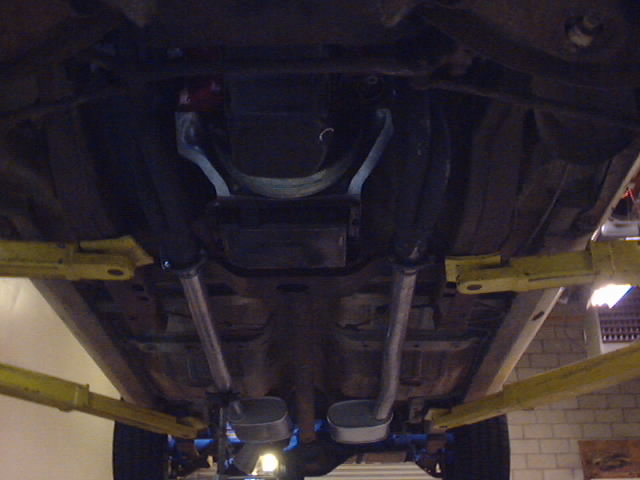 Undercarriage view of a vehicle with dual exhaust pipes and a driveshaft