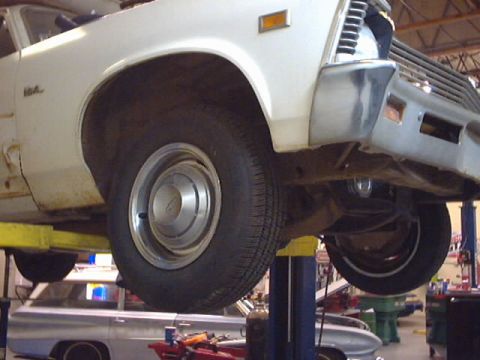 1969 Chevrolet Nova - A white 1969 Chevrolet Nova is shown on a lift, revealing its front quarter and underside.