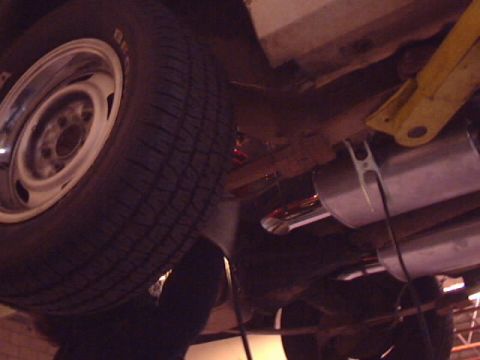 1969 Chevrolet Nova - The underside of a vehicle is shown, focusing on the wheel and exhaust system components. A SuperMotors logo is present.