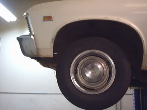 1969 Chevrolet Nova - Close-up of the front fender and wheel of a 1969 Chevrolet Nova, showing the chrome bumper and an amber turn signal indicator.