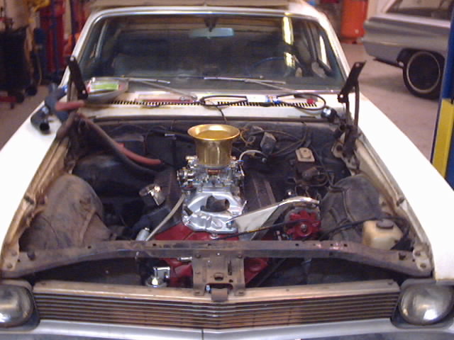 1969 Chevrolet Nova engine bay with a gold air cleaner and chrome carburetor
