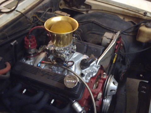1969 Chevrolet Nova - Engine bay view of a V8 motor with custom air intake and carburetor setup.
