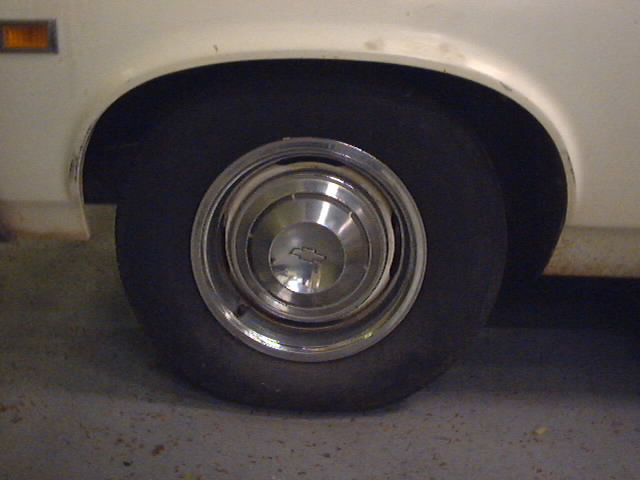 White 1969 Chevrolet Nova rear wheel and fender with chrome hubcap