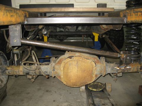 1990 Ford F-250 - Close-up view of a truck's rear axle and suspension system, showing custom fabrication work.