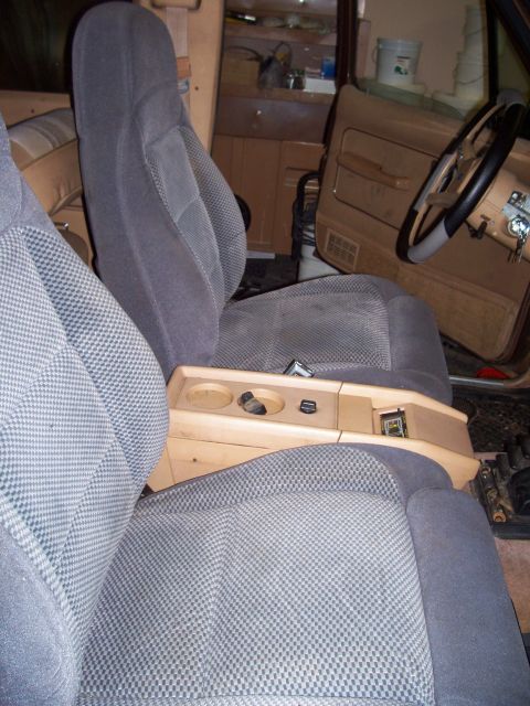 1984 Ford Bronco II - The interior of the vehicle features cloth seats and a custom wooden center console with cup holders and storage.