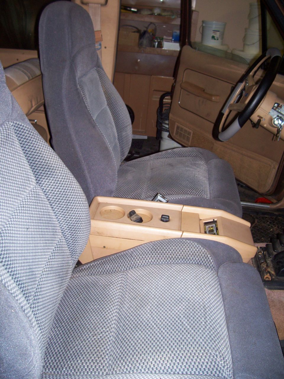 Interior shot of a vehicle, showing front seats, center console with cup holders, and steering wheel