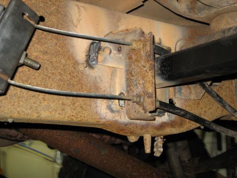 1990 Ford Bronco - This photo shows the underside of a vehicle, focusing on the rusty frame and suspension components, with visible welding marks.