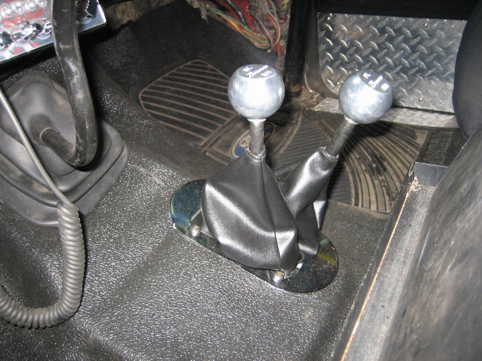 1990 Ford Bronco interior showing two gear shift knobs and black boots