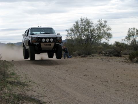 1980 Ford Bronco - This 1980 Ford Bronco is airborne on a dusty desert trail, captured by a photographer on the ground.