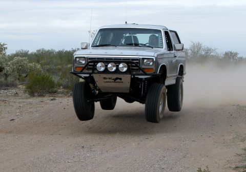 1980 Ford Bronco - This modified Ford Bronco is airborne on a dusty trail, its off-road capabilities.