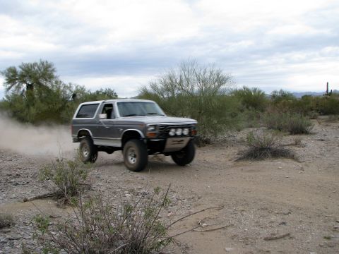 1980 Ford Bronco - This 1980 Ford Bronco is captured mid-action as it navigates a dusty off-road trail.
