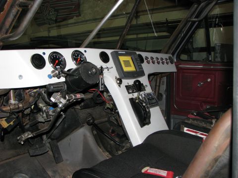1980 Ford Bronco - The interior of a 1980 Ford Bronco shows a modified dashboard with multiple gauges and a central navigation screen.