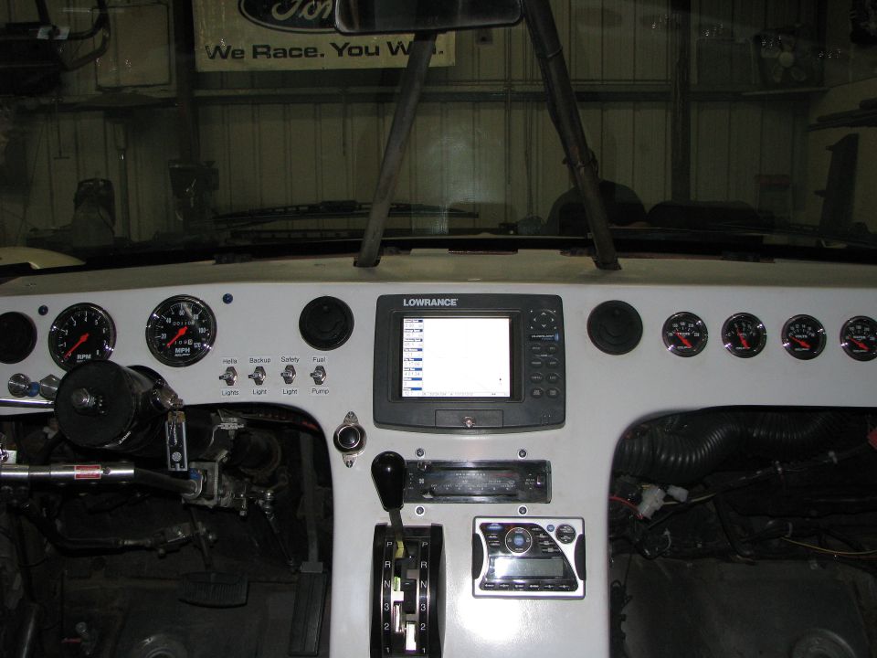 Custom dashboard with Lowrance GPS, multiple gauges, and aftermarket stereo. Steering column and shifter visible