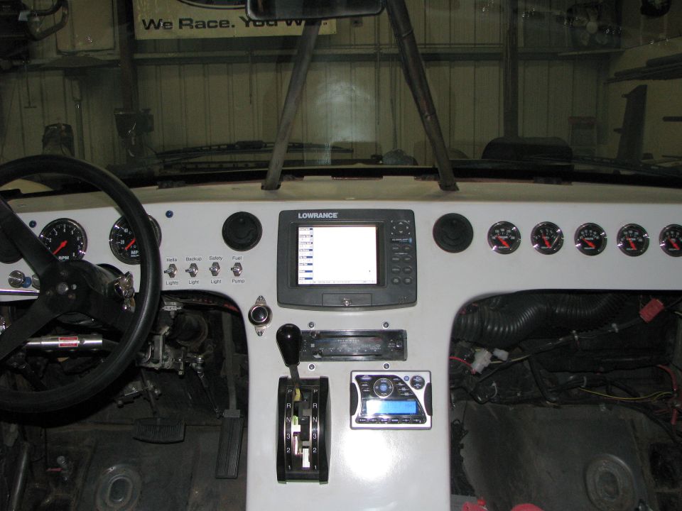 Dashboard with steering wheel, Lowrance GPS, gauges, and shifter. Some wiring visible