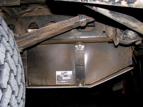 1980 Ford Bronco - Close-up view of a vehicle's undercarriage, focusing on mechanical components and a manufacturer's label.