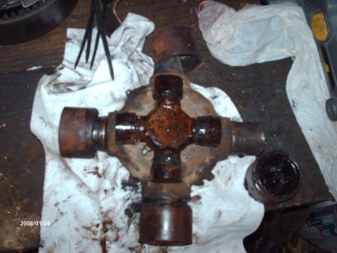 1990 Ford F-150 - Universal joint part, likely from a drivetrain, covered in grease and rust.