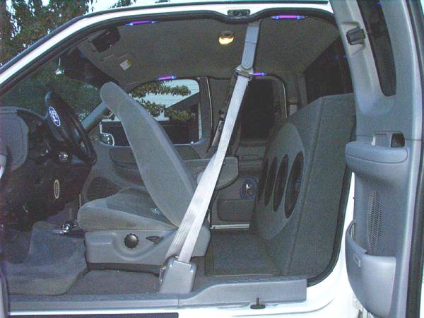 Ford extended-cab pickup interior with gray seats and a custom three-speaker subwoofer box