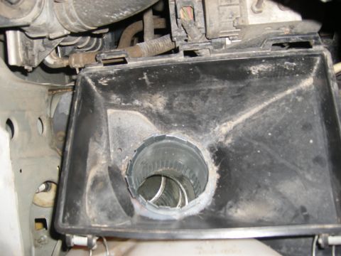2001 Ford Crown Victoria - Close-up of a dusty air intake housing with a metal duct visible inside the opening.